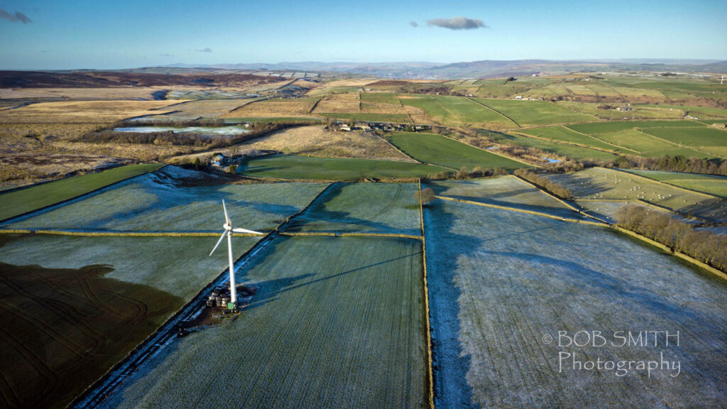 A drone picture of Oakworth Moor and the hamlet of Broad Head, with the hills of the Three Peaks area in the far distance