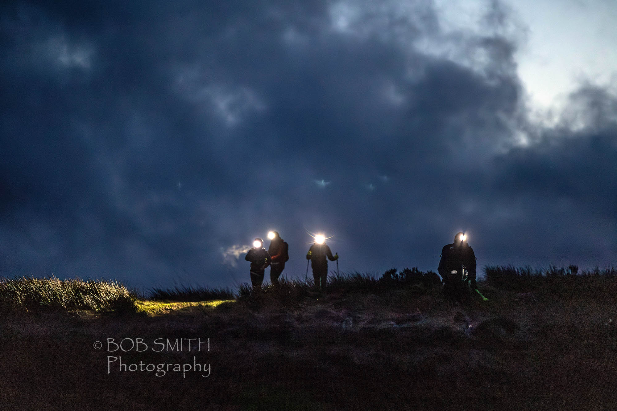 Runners in the Spine Race head north as night falls on the Pennine Way