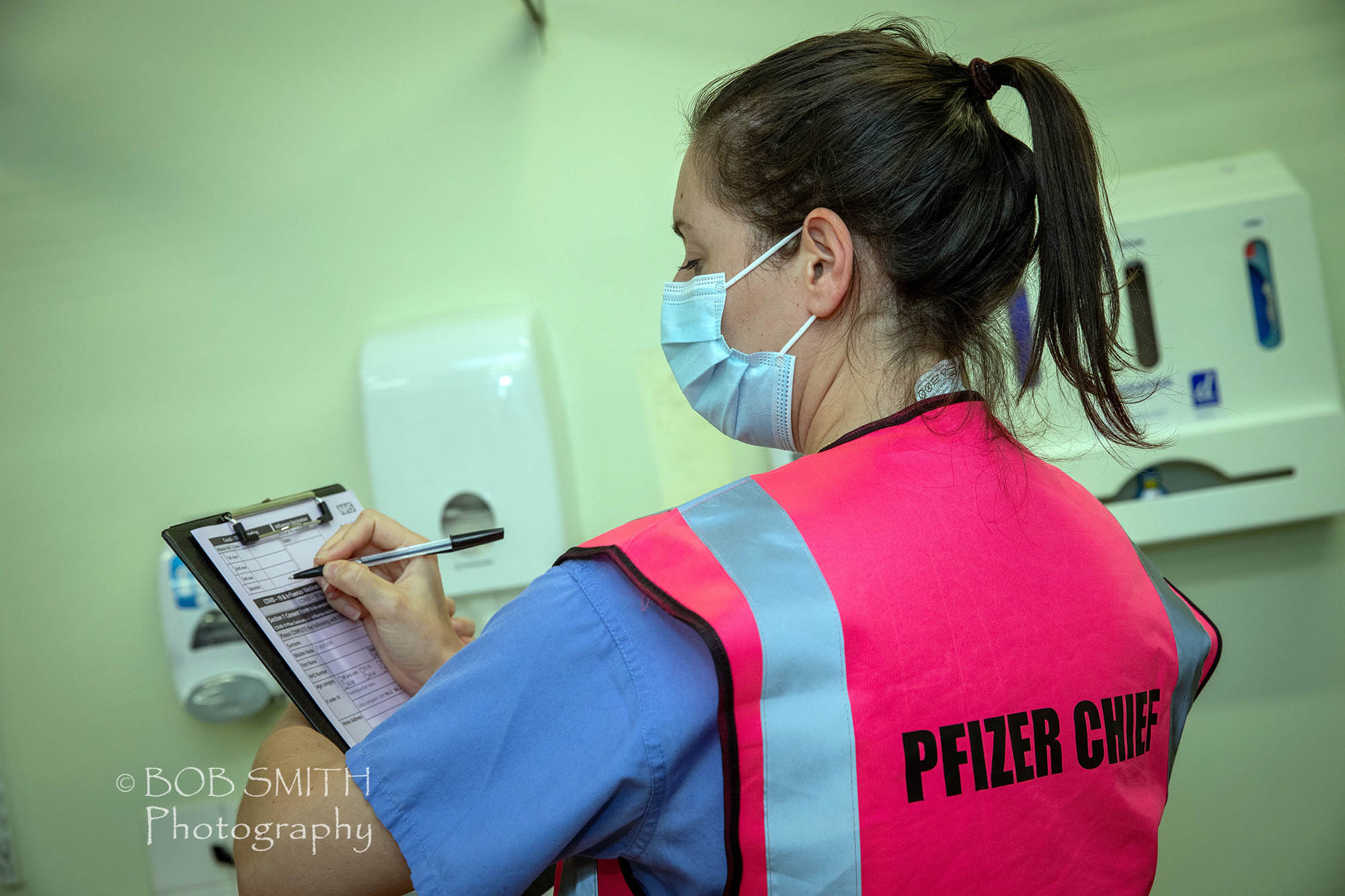 One of the medical staff in Airedale Hospital's Covid-19 vaccination centre sports a Pfizer Chief tabard. 