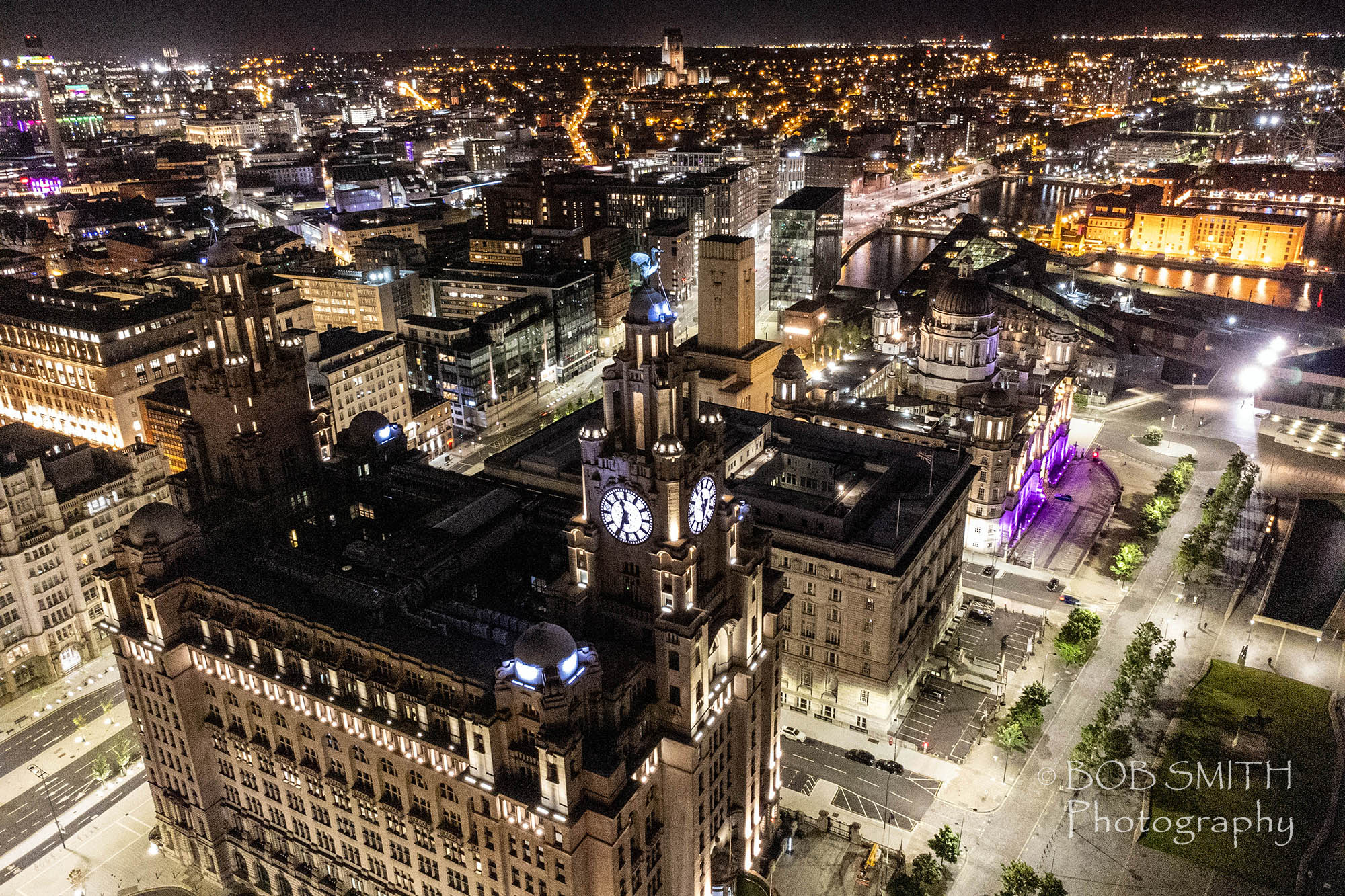 The Three Graces buildings at Liverpool Pier Head in a night drone shot