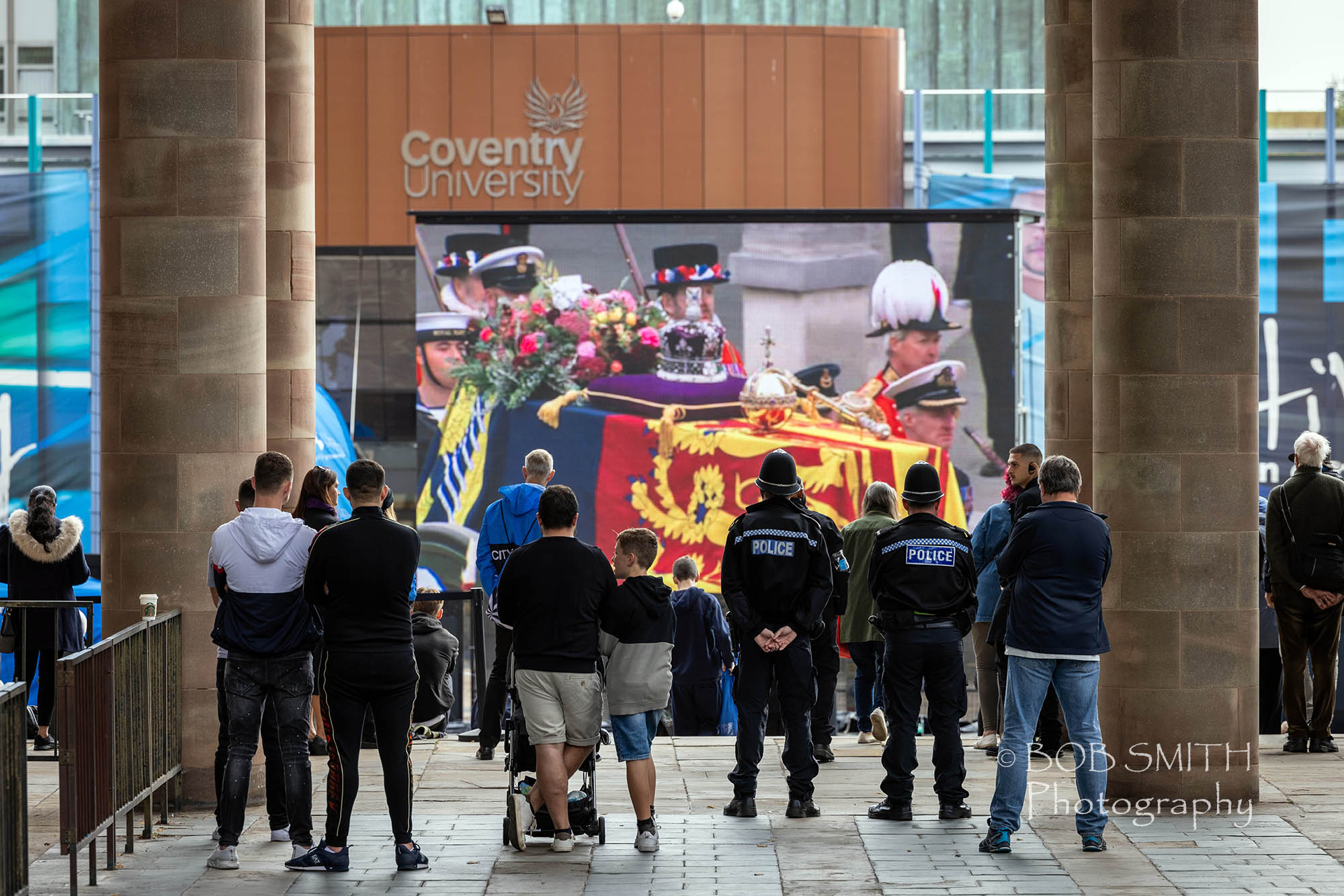 Members of the public watch the Queen's funeral on a giant screen placed next to Coventry Cathedral