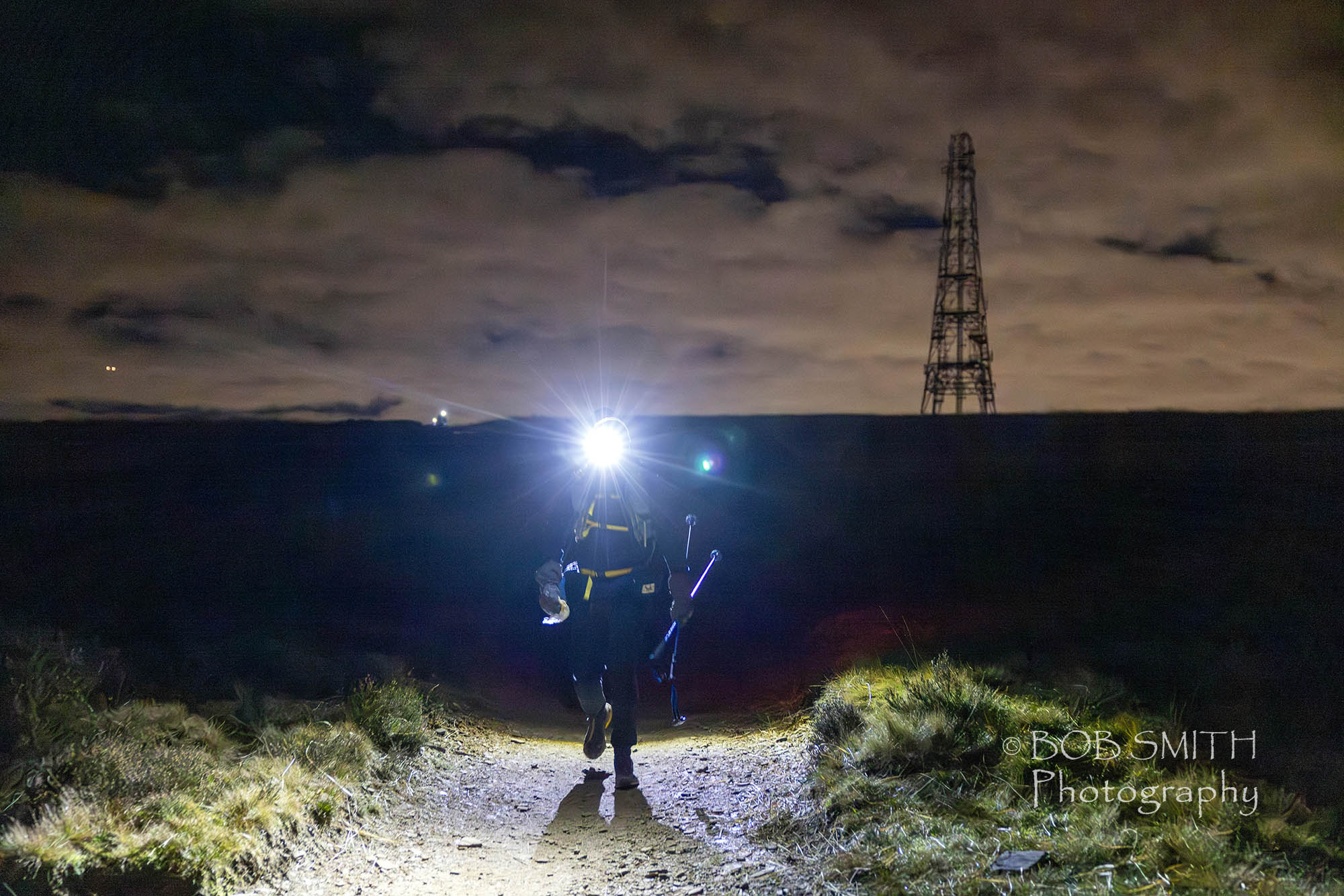 A Spine Race runner passes Windy Hill on the Pennine Way